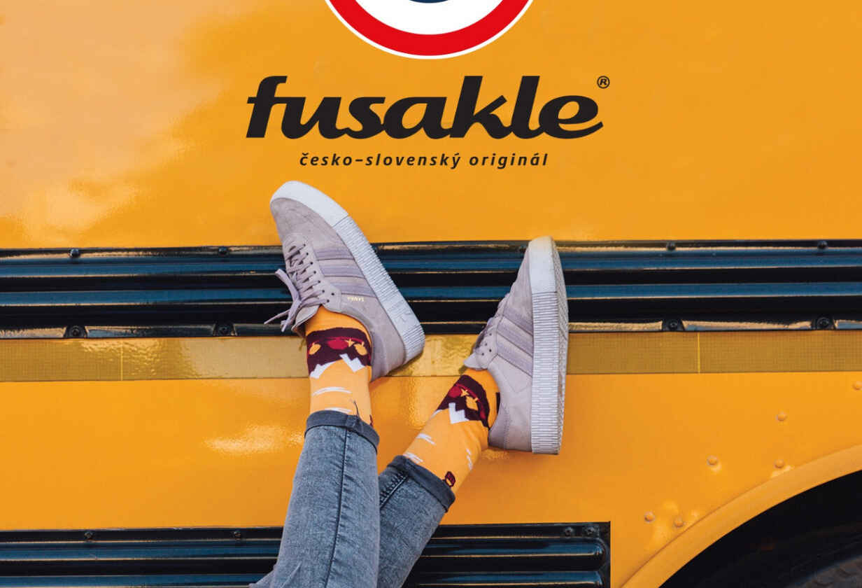 detail nohou modelky v barevných ponožkách a logo značky Fusakle