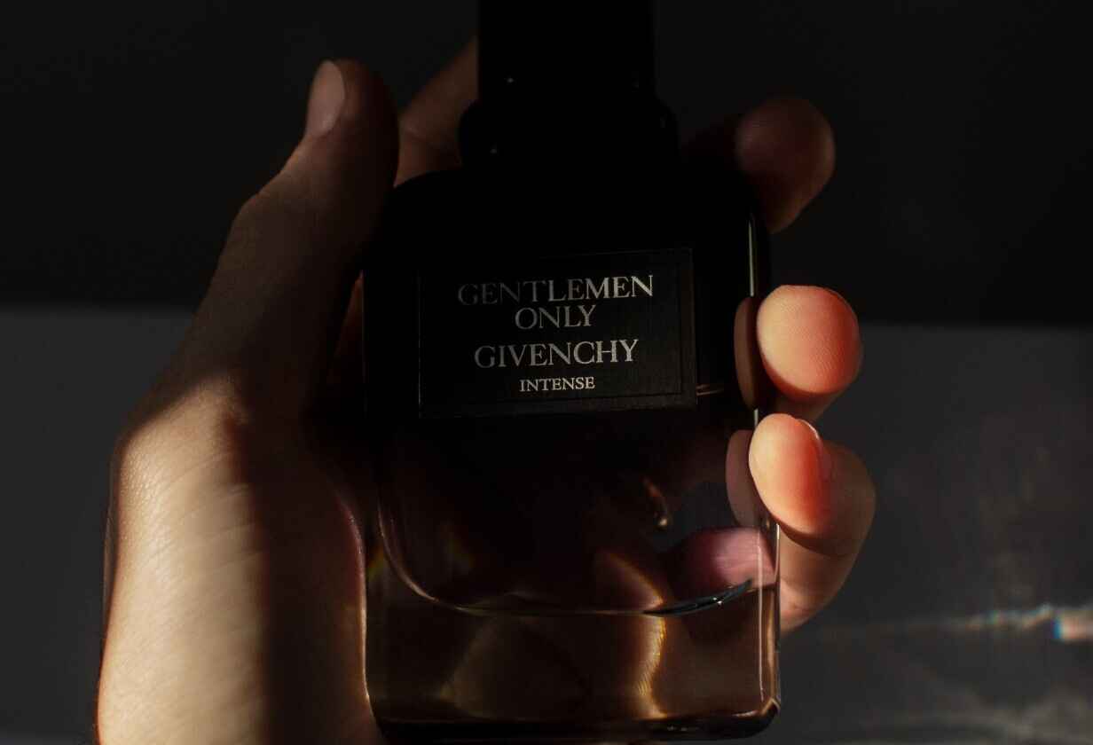 detail ruky muže držíci parfém