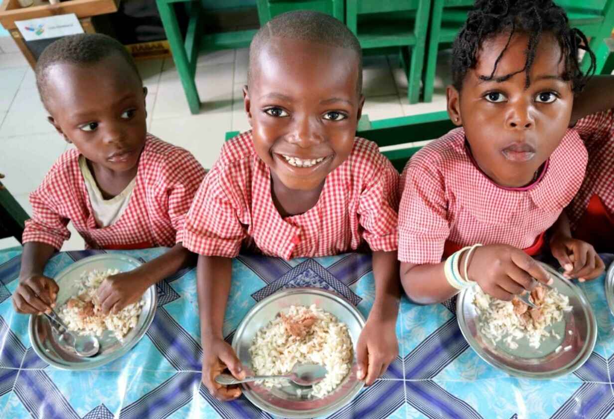 usmívající se děti u stolu s jídlem