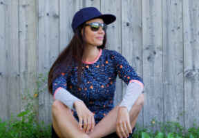 sedící žena v slunečních brýlích a čepici značky Lasoul