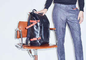 pózující muž s batohem na židli