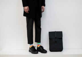 muž v černém outiftu s barevnými ponožkami We are ferdinand
