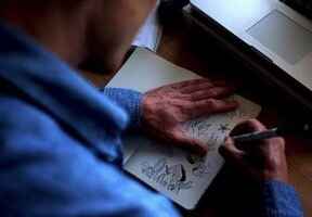 muž kreslící do skicáku