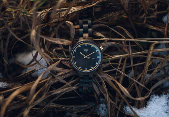 dřevěné hodinky v suché trávě