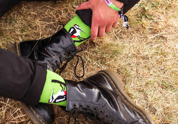 detail nohou modela v zelených ponožkách a kotníkových botách