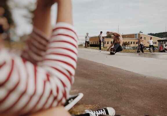 žena sledující skateboardisty v pozadí