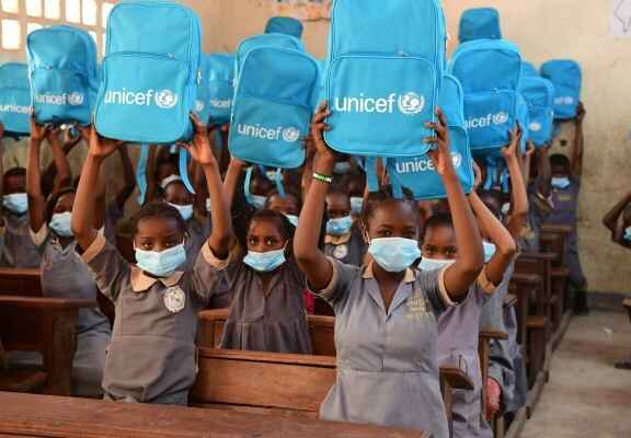děti ve škole držící batohy UNICEF