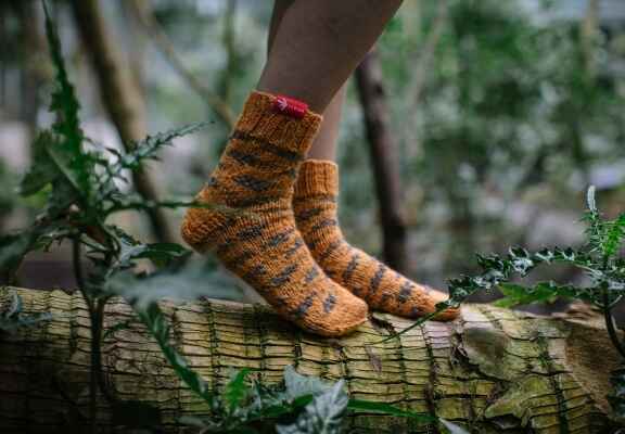 nohy modelky v barevných, pletených ponožkách