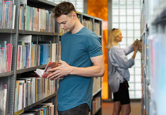 muž v tričku v knihovně