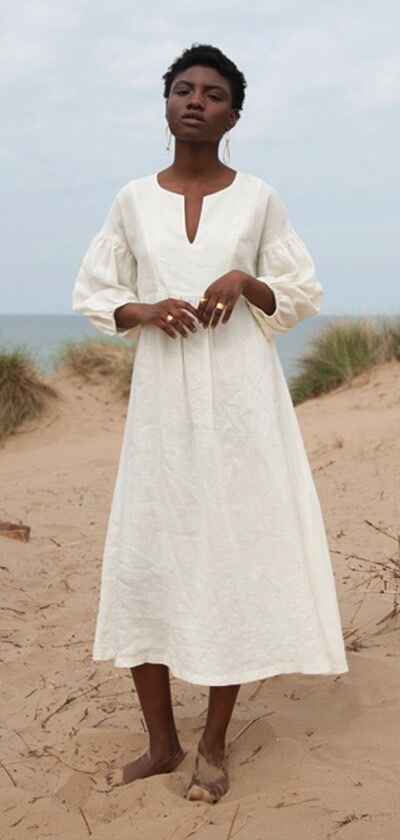 modelka v bílých, letních šatech na pláži