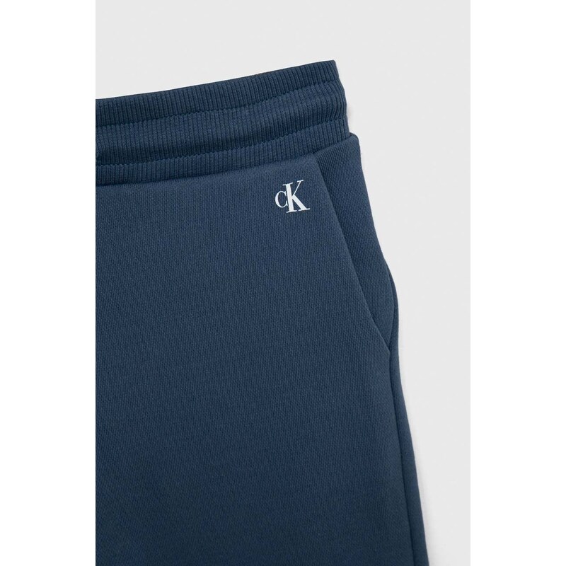 Dětské bavlněné tepláky Calvin Klein Jeans tmavomodrá barva, s potiskem