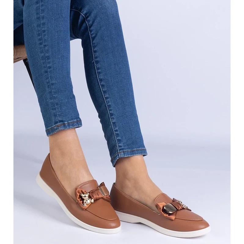Gemre Brown moccasins decorated with a bow and a golden teddy