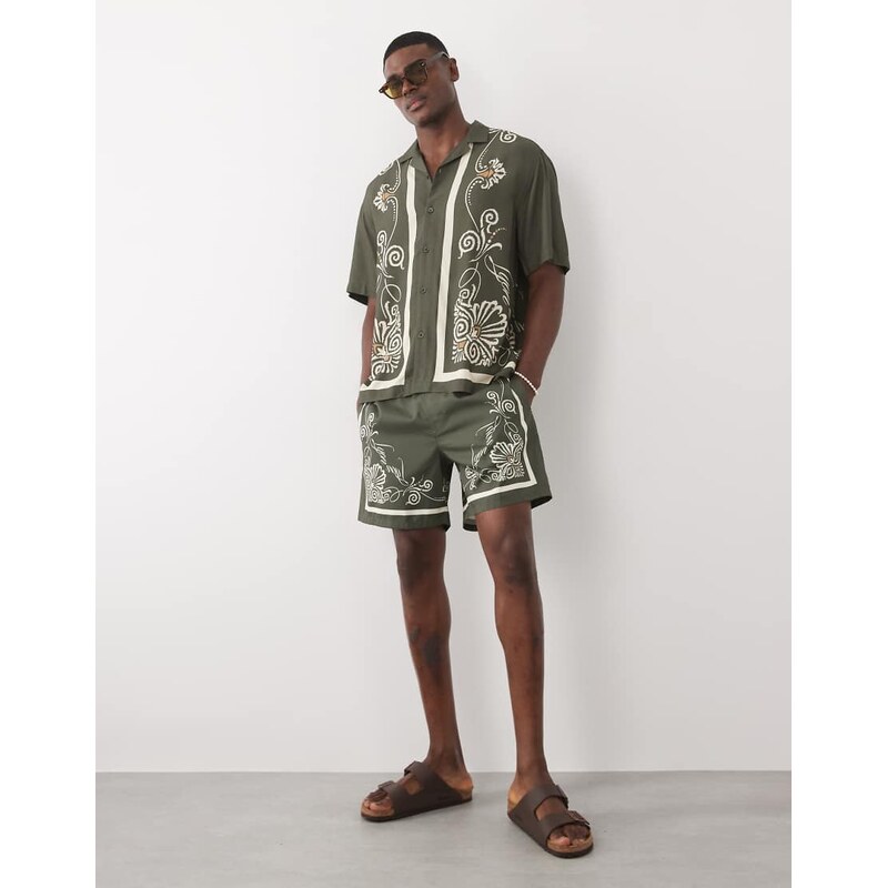 ASOS DESIGN co-ord swim shorts in short length with border print in green-Black