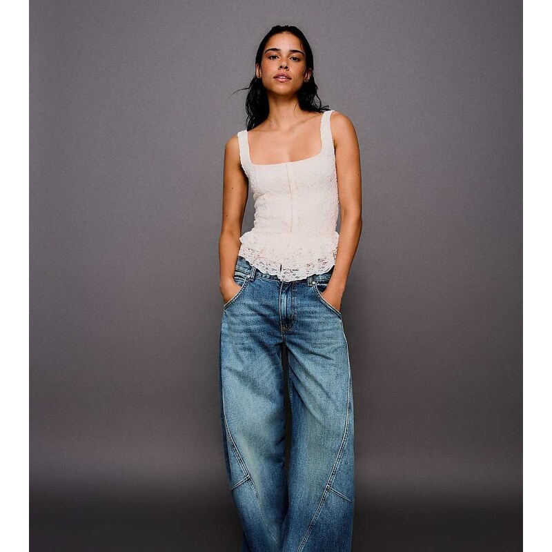 Bershka Petite low-rise barrel jeans in mid blue